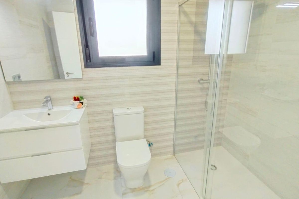 Moderne badkamer met een douche en stijlvolle armaturen in een villa in Pilar de La Horadada.