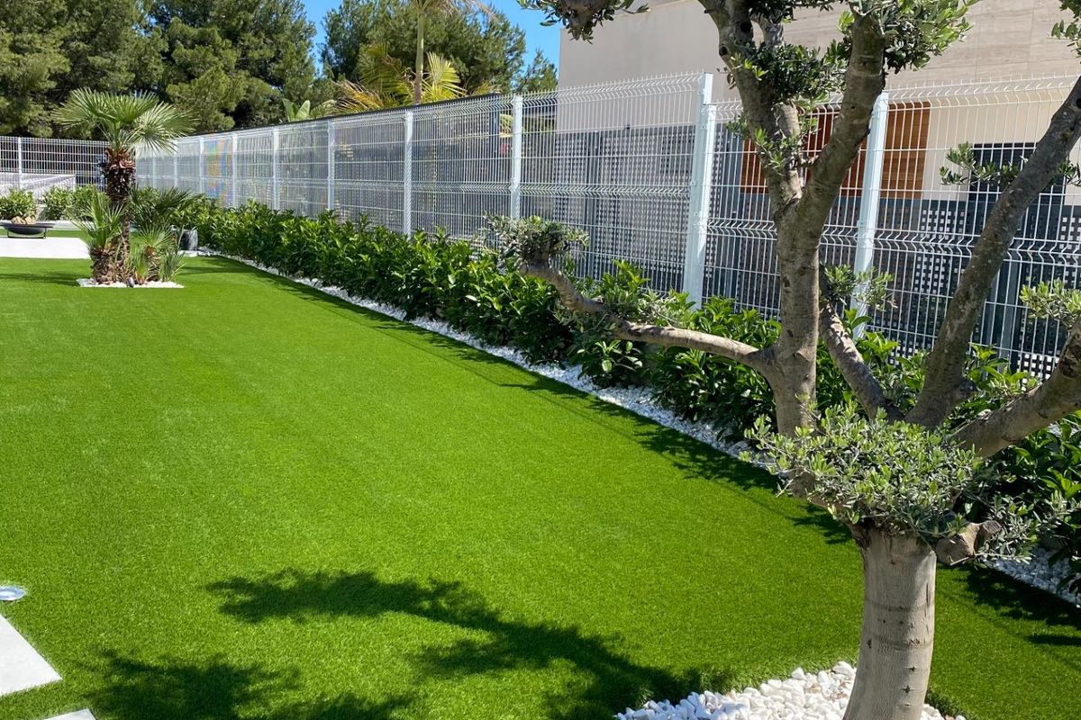 Weelderig groen gras en palmboom in de tuin van de villa in Finestrat. Perfect voor ontspanning.