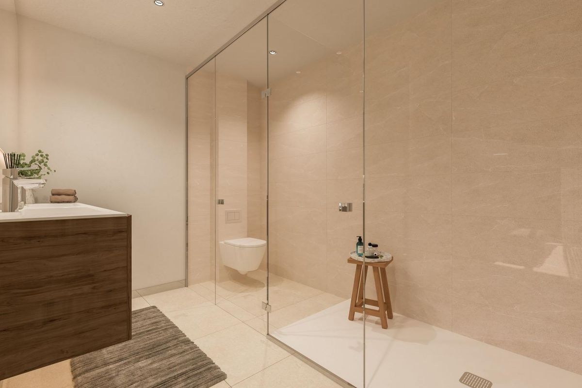 Strakke badkamer in het penthouse in Manilva, met moderne armaturen en een glazen douche.
