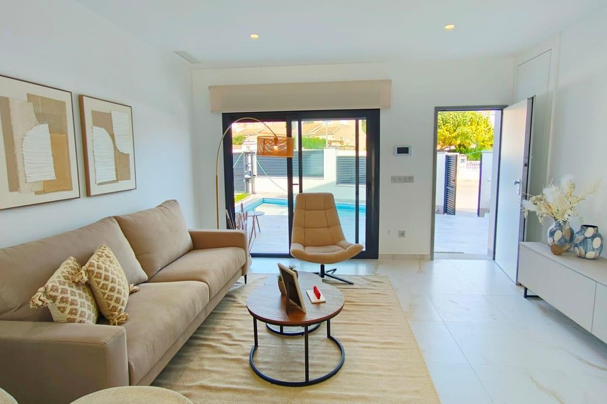 Gezellige woonkamer van de villa, ingericht met moderne meubels en uitzicht op het zwembad in Pilar de La Horadada.
