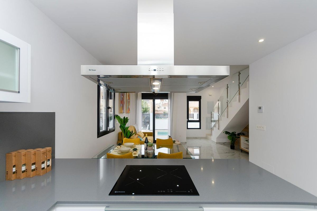 Strak keukenontwerp met moderne apparaten, deel van de gemeenschappelijke woonkamer in de villa in Torrevieja.