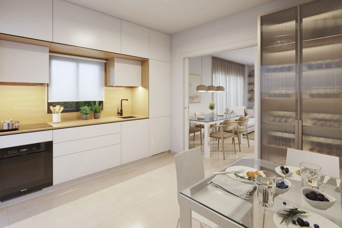Modern kitchen with dining area in a 3-bed villa, Mazarron. Sleek white cabinets, light wood, and integrated appliances.
