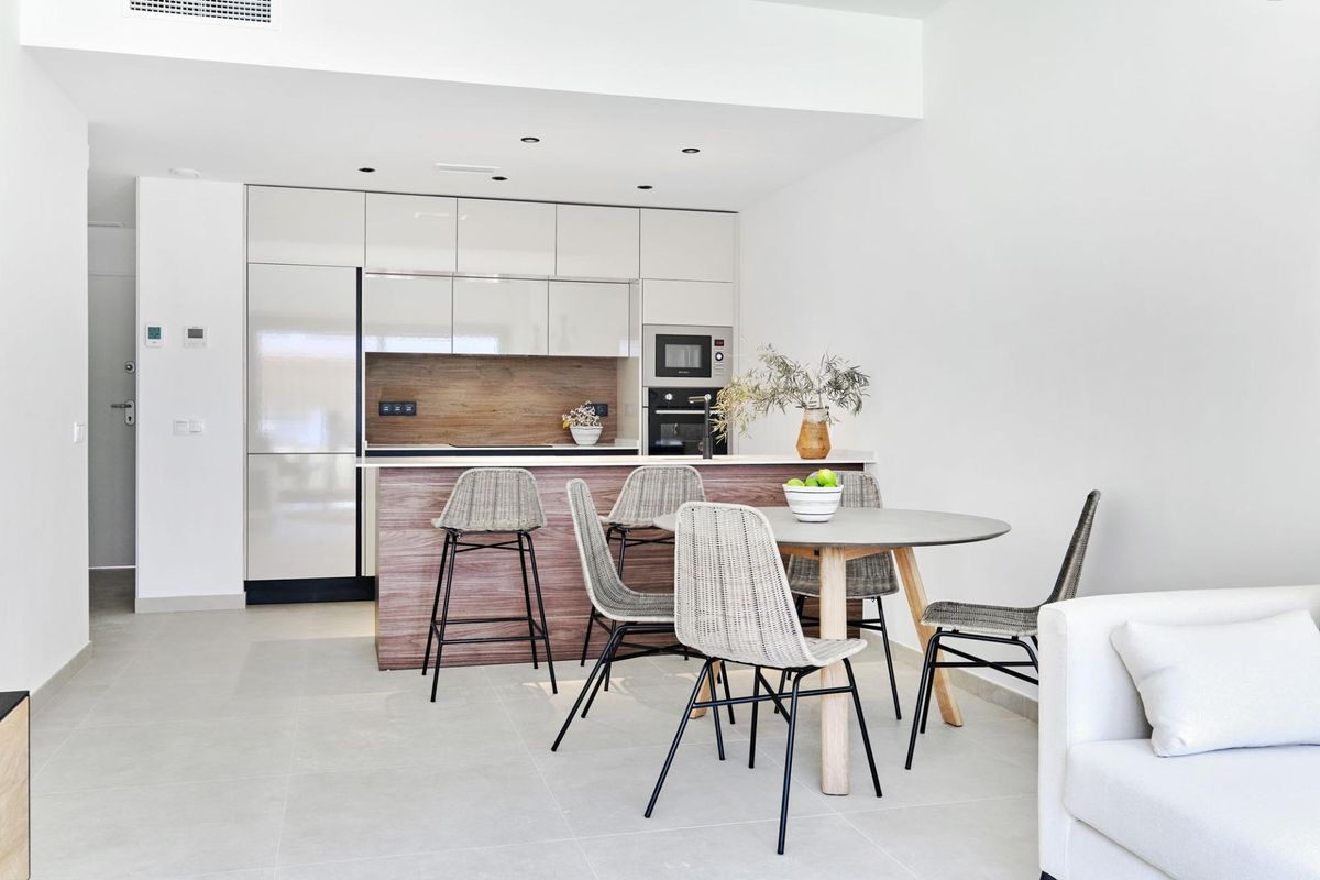 Moderne keuken en eetkamer in een bungalow in Torrevieja, uitgerust met strakke meubels en apparaten.