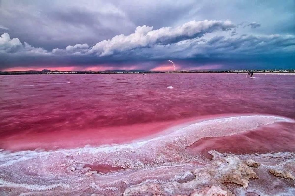 Uniek roze zoutmeer met dramatische wolken in Torrevieja, een voorbeeld van de schoonheid van de natuur.