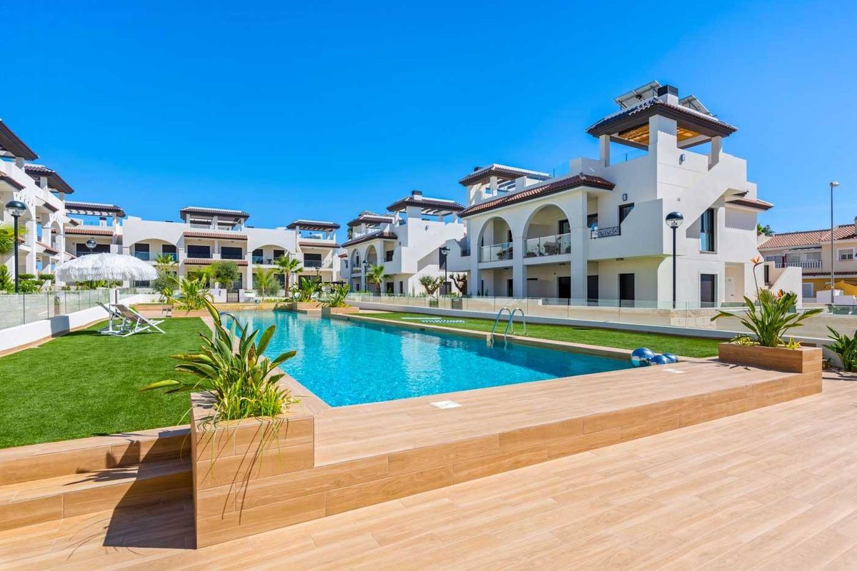 Seren uitzicht op het zwembad dat de blauwe lucht reflecteert in Rojales, Costa Blanca Zuid, Spanje.