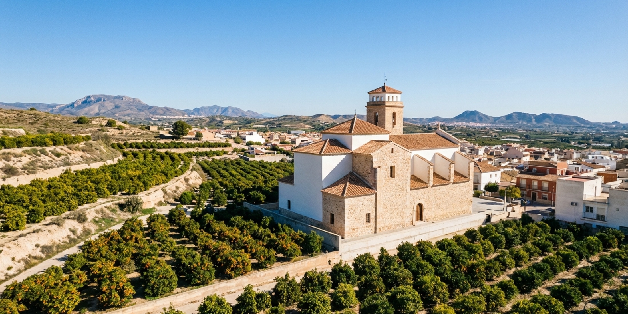Panoramisch uitzicht op de kerk van San Miguel de Salinas en citrusboomgaarden