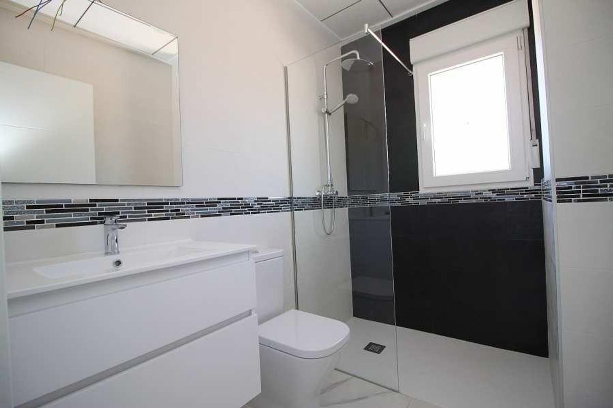 Moderne badkamer met een strakke uitstraling, douche en dubbele wastafels in een villa in Pinoso.