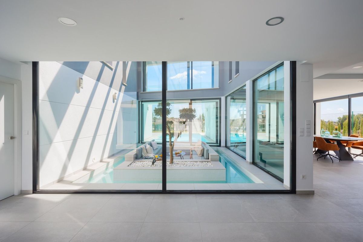 Modern living space with glass walls overlooking the pool area in Baños y Mendigo, Costa Calida villa.