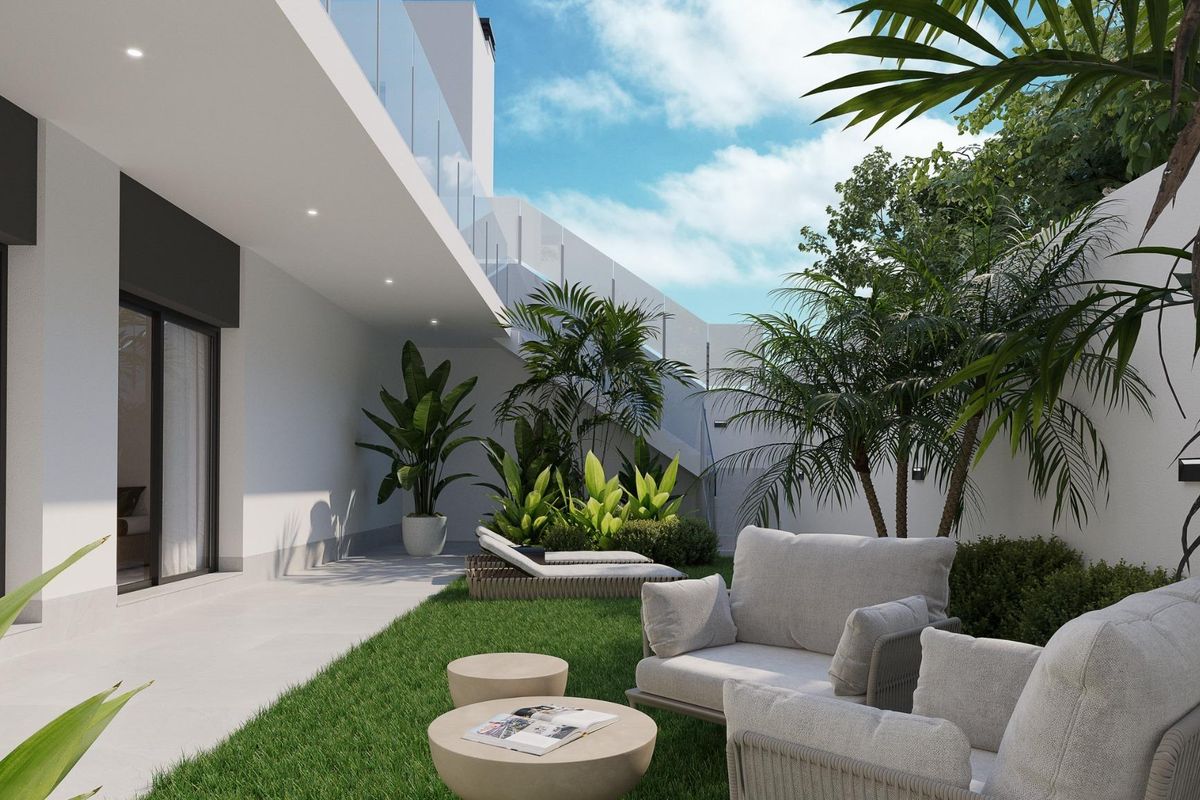 Weelderig tuinarea met zitplaatsen en tropische planten in de binnenplaats van een villa in Finestrat, Costa Blanca.