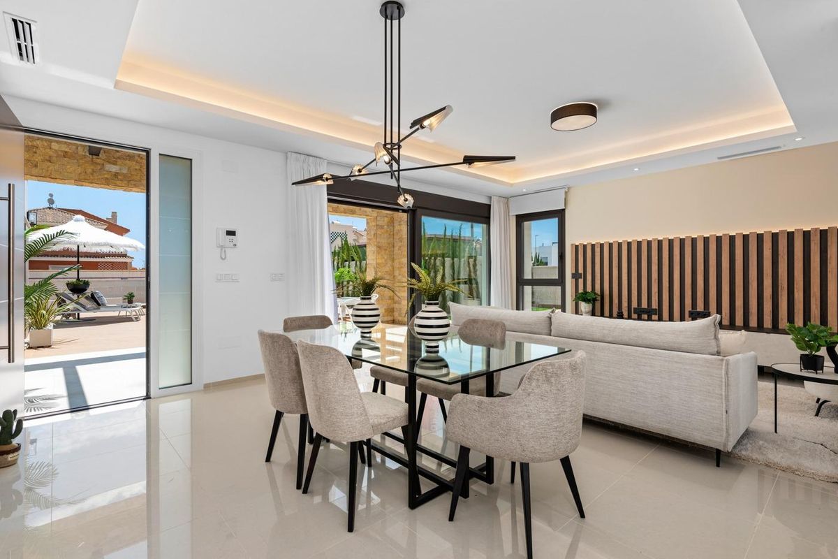 Eetruimte met modern interieur en uitzicht op het terras in een stijlvolle villa in Ciudad Quesada, Spanje.