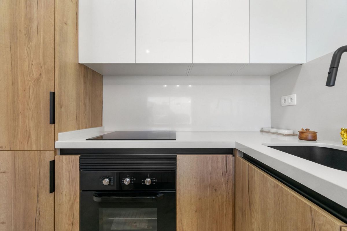Moderne keuken met houten kasten en witte werkbladen in een appartement in San Javier.