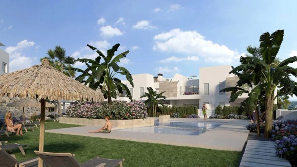 Swimming pool area with tropical plants and sun loungers at a residential complex in Algorfa, Costa Blanca South.
