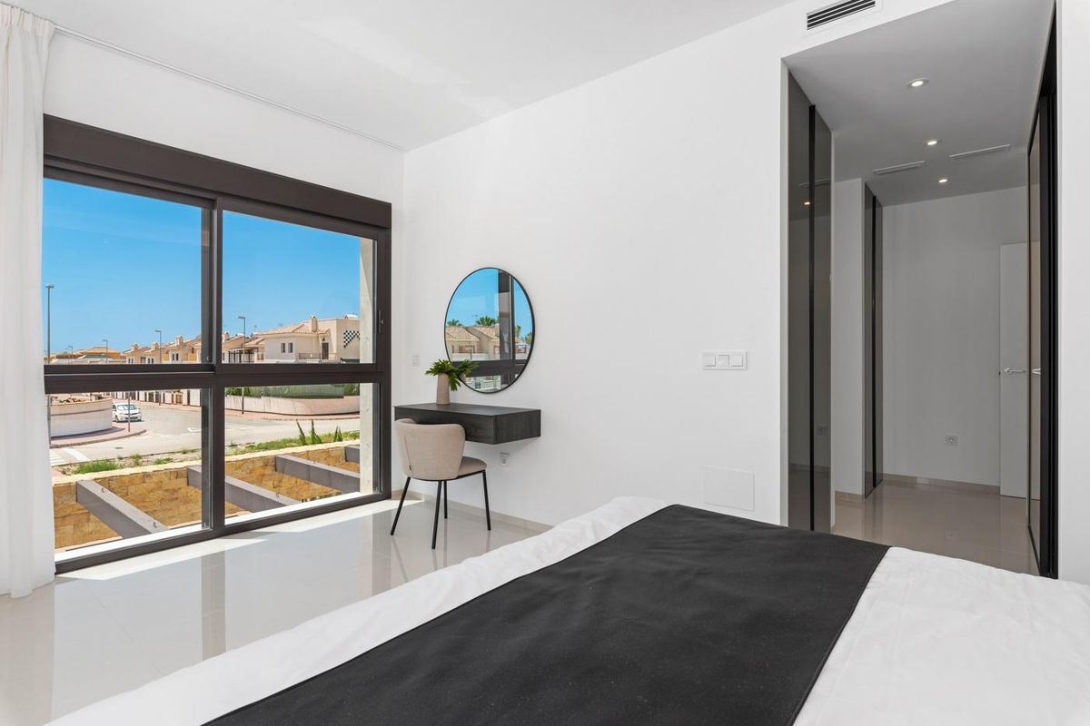 Contemporary slaapkamer met een stijlvolle bureau en grote ramen in een villa in Ciudad Quesada.