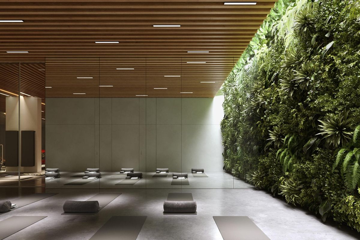 Yoga studio met oefenmatten en een groene muur, gelegen in een premium penthouse in Marbella, Costa del Sol.