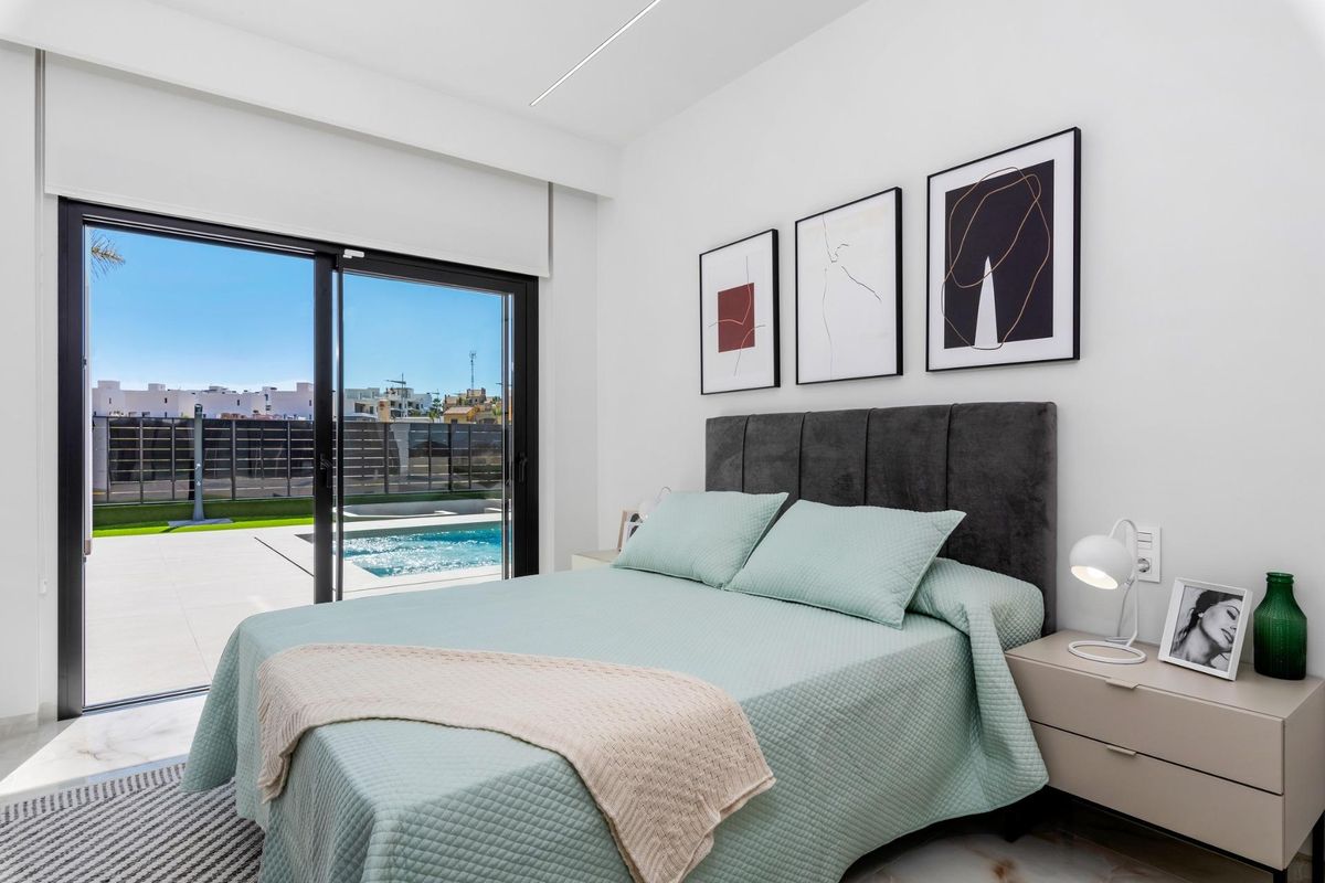 Heldere slaapkamer met uitzicht op het zwembad in een moderne 3-slaapkamer villa in Algorfa, Costa Blanca Zuid.
