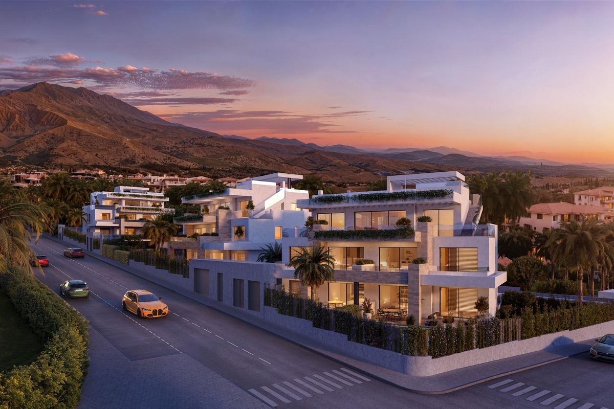 Luchtfoto van een modern 2-slaapkamerappartementcomplex in Estepona, omringd door bergen en weelderig groen.