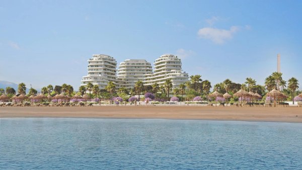 Uitzicht op moderne appartementen aan het strand in Málaga, met palmbomen en heldere bloemen op de voorgrond.
