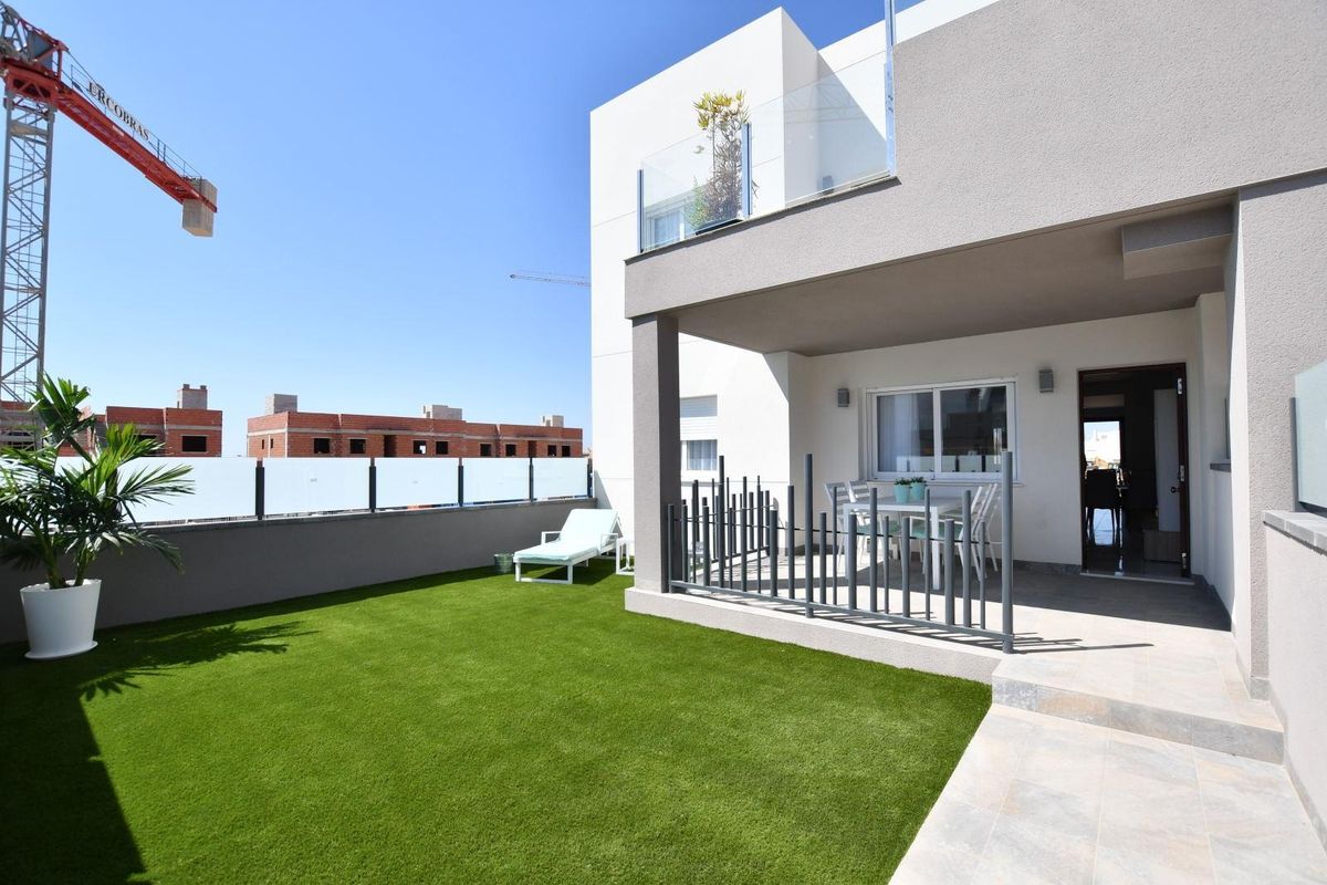 Terras op de begane grond van een modern 2-slaapkamerappartement in San Miguel de Salinas, met een goed onderhouden gazon.