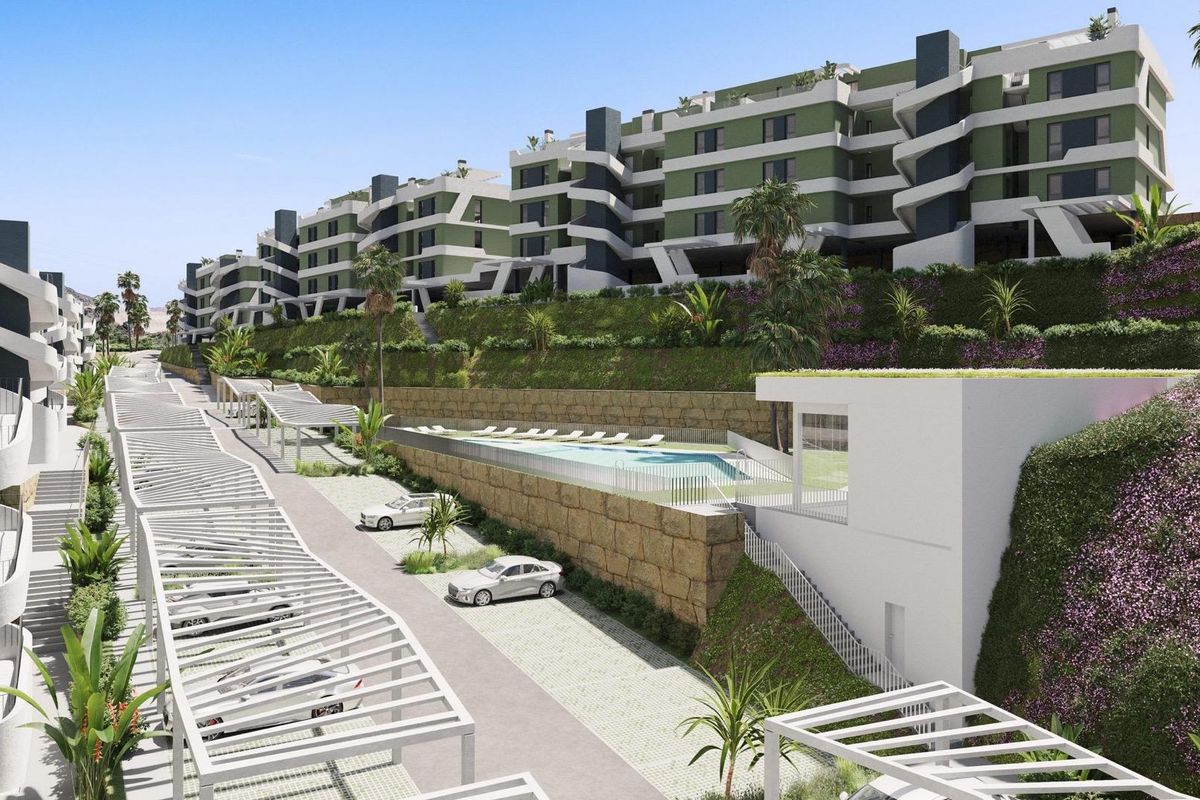Buitenkant van een modern appartementencomplex met weelderig groen in Mijas, Costa del Sol, Spanje.