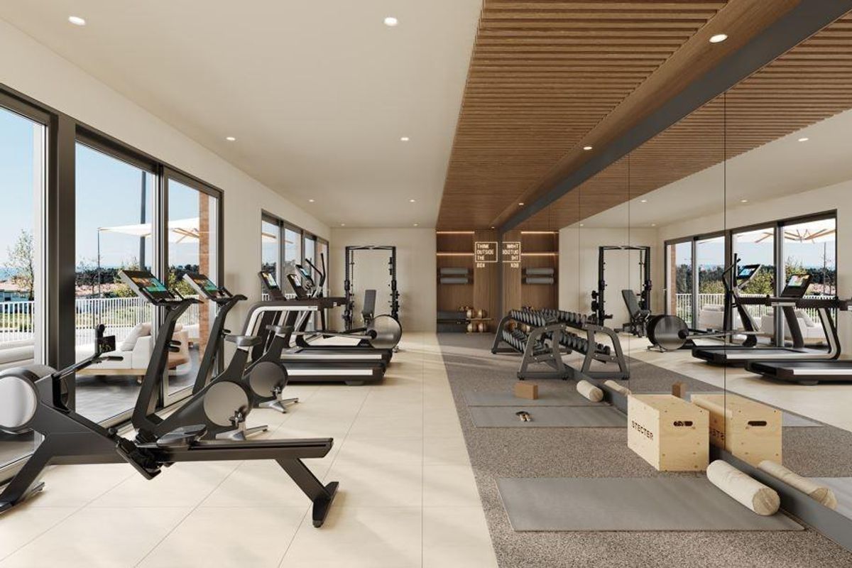 Goed uitgeruste fitnessruimte met moderne machines en natuurlijk licht in Mijas, Costa del Sol.