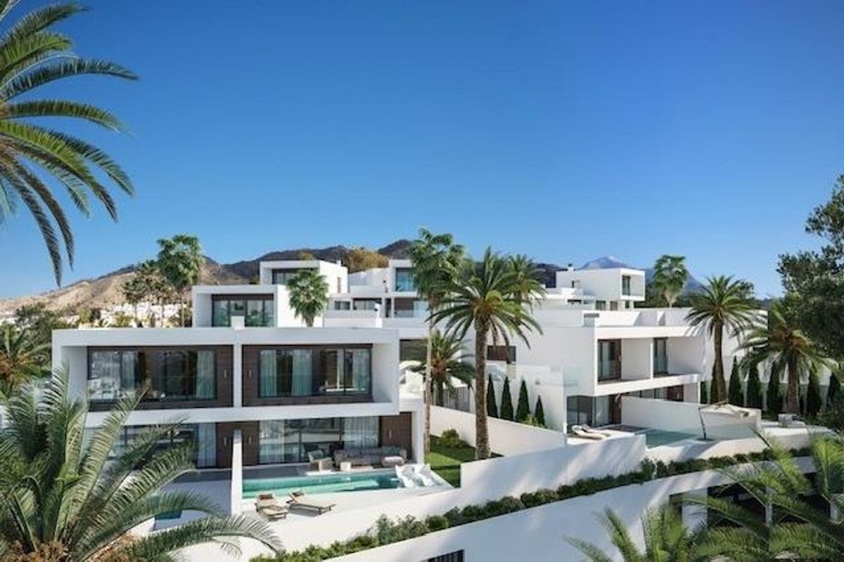 Adembenemend uitzicht op een 3-slaapkamer villa complex in Nerja, met palmbomen en moderne architectuur.