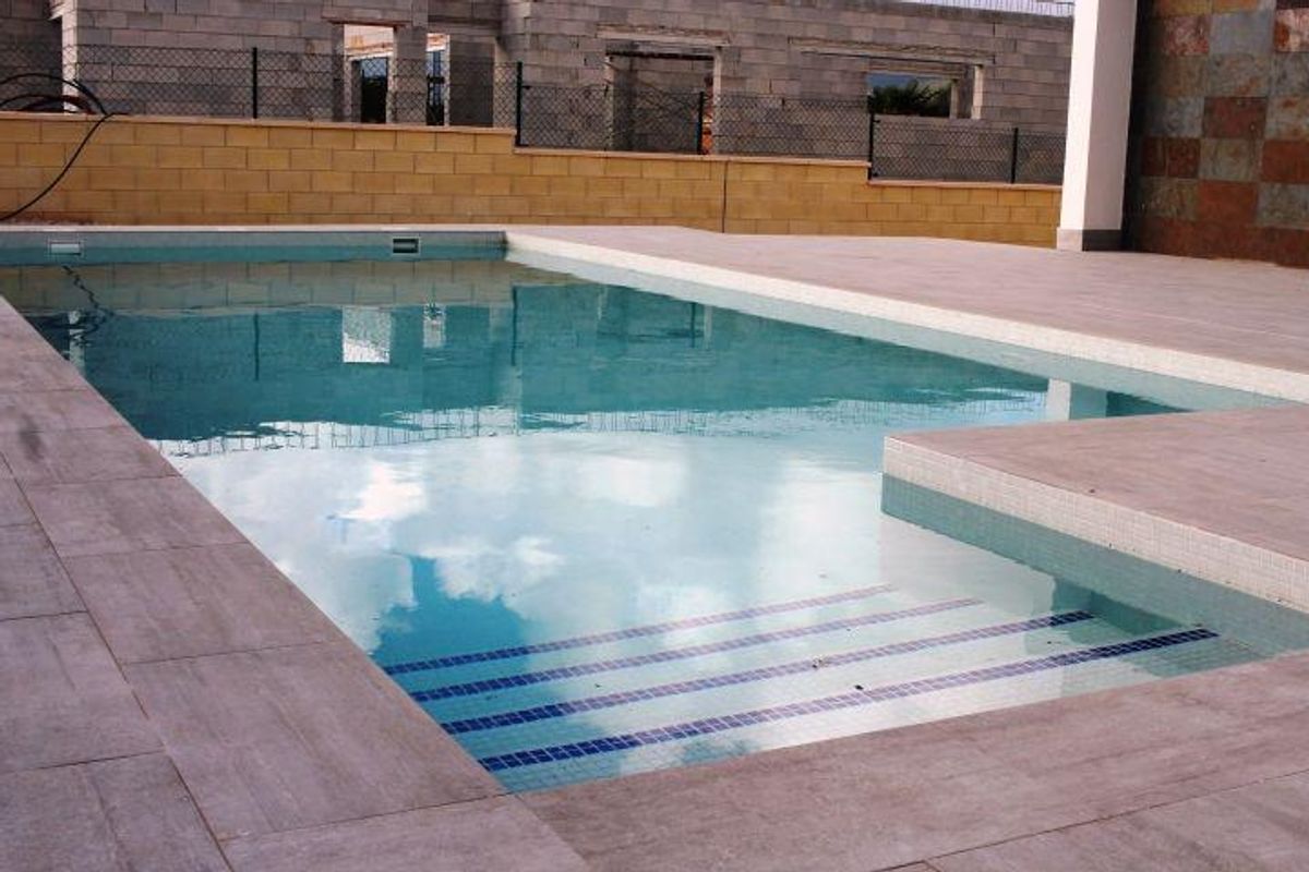 Reflectie in het zwembad van de villa, omringd door een modern terras, dat de serene omgeving van La Romana vastlegt.