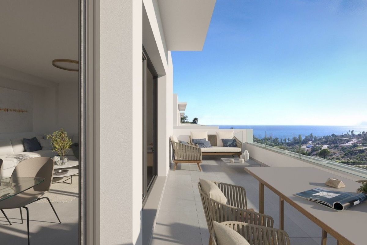 Exterior view from interior to large terrace. Costa del Sol townhouse includes terrace with dining and lounge area. Coastal view.