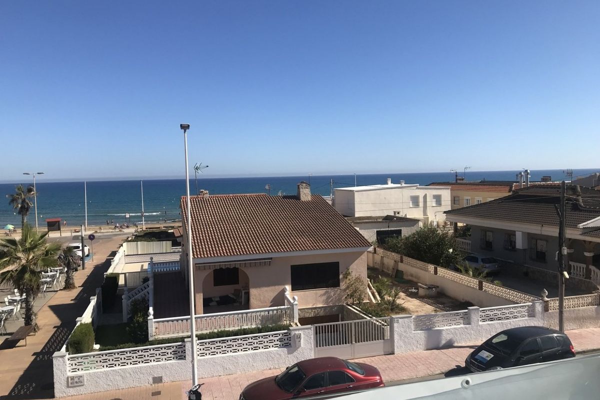 Uitzicht op huizen aan het strand in Torrevieja, met de ongerepte kustlijn en nabijgelegen voorzieningen.