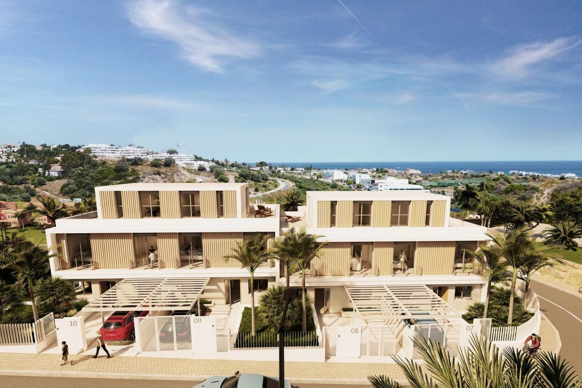 Vooraanzicht van een moderne townhousecomplex in Estepona, Costa del Sol, met eigentijdse architectuur.