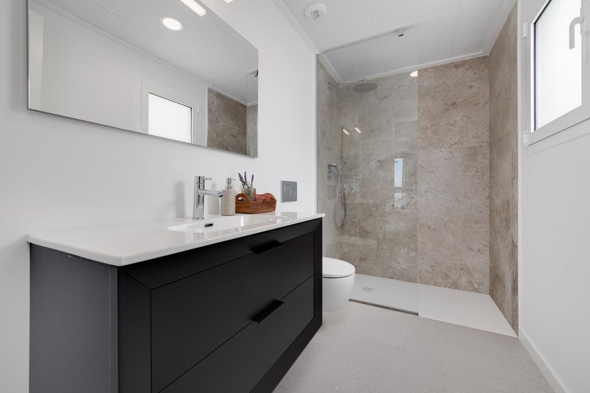 Moderne badkamer met een douche en stijlvolle zwarte meubels in een 3-slaapkamer villa in Mutxamel, Costa Blanca.