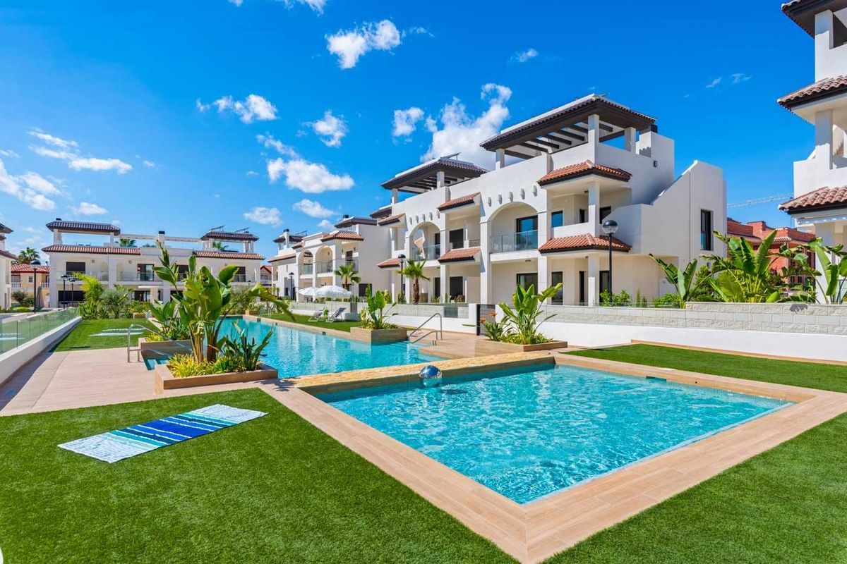 Uitzicht op het zwembad omringd door gras en tuinen in Rojales, Costa Blanca Zuid, Spanje.