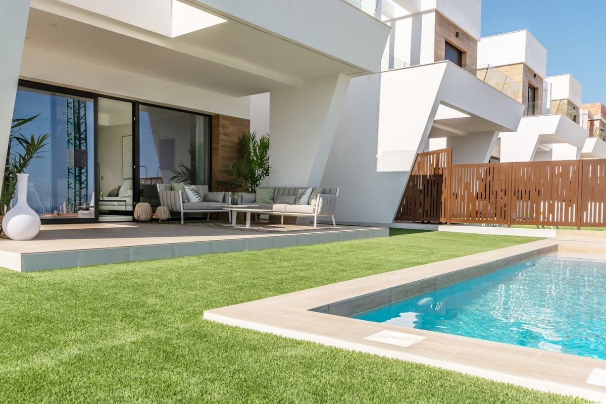Exterior of a modern villa in Finestrat, Costa Blanca, featuring a swimming pool, artificial grass, terrace and stylish furniture.