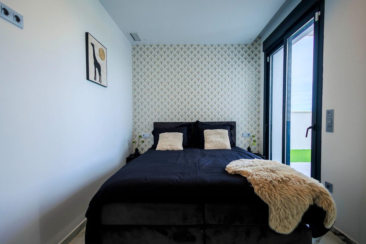 Gezellige slaapkamer in de villa met moderne inrichting en toegang tot het terras in Pilar de La Horadada.
