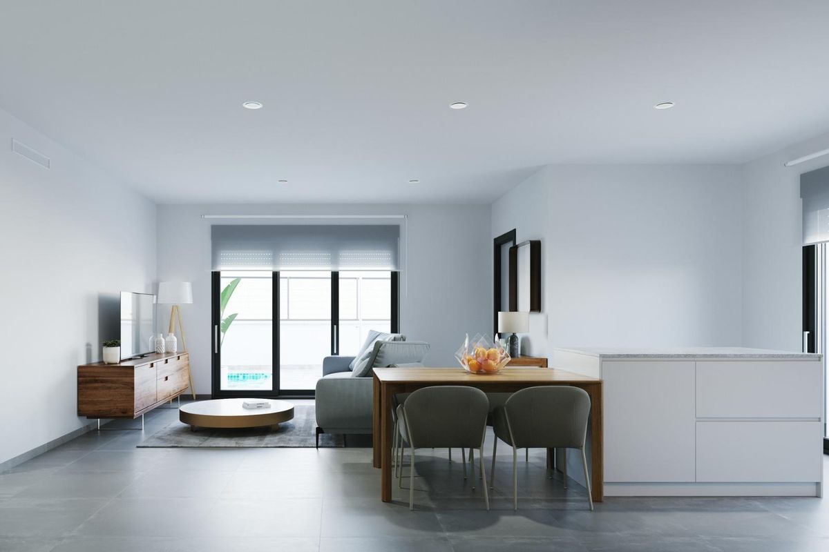 Woonkamer van de bungalow met strak ontwerp, eettafel en uitzicht op het terras in Torre Pacheco.