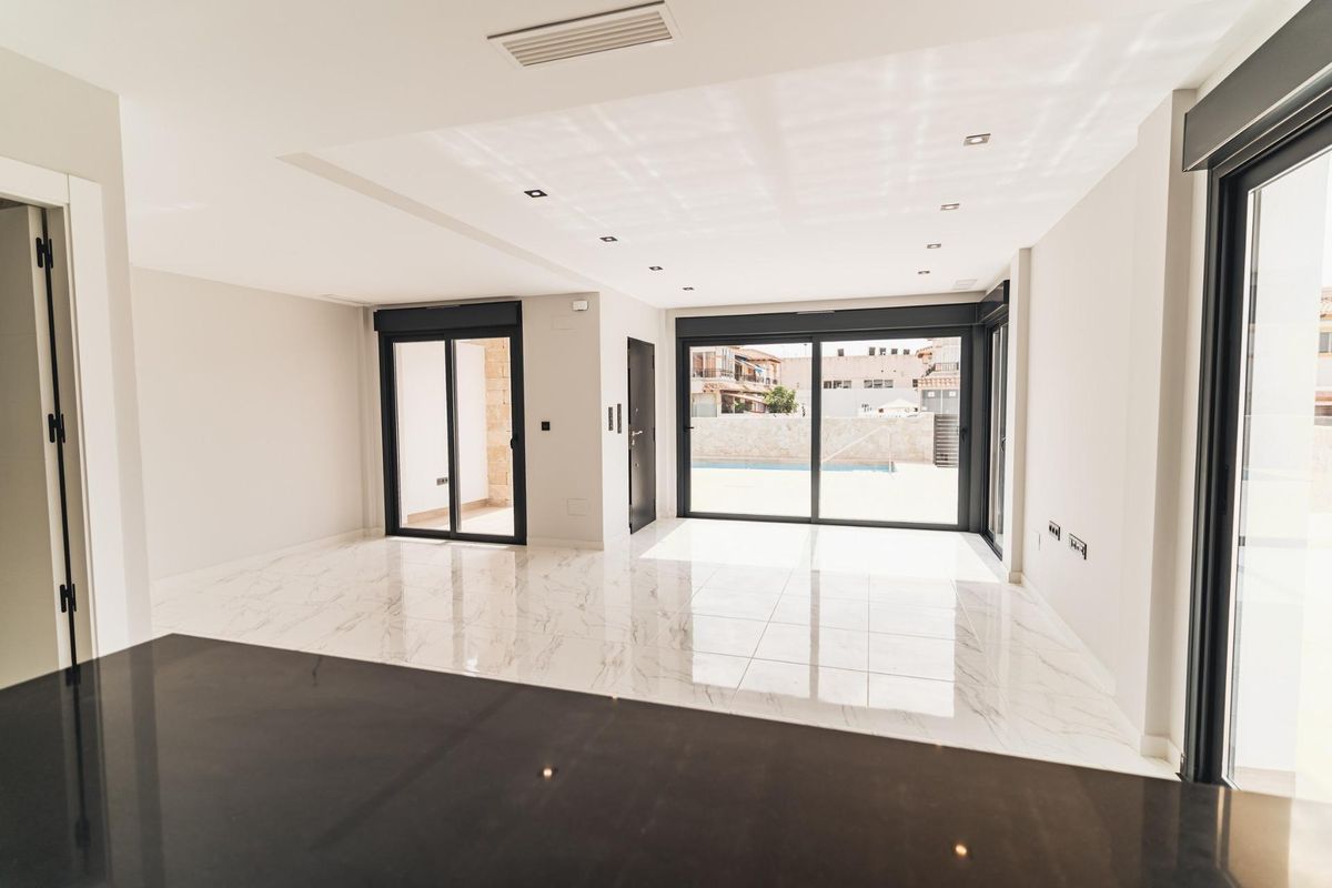 Heldere woonruimte van de villa met grote ramen, met uitnodigende uitzichten op buiten in Orihuela Costa.