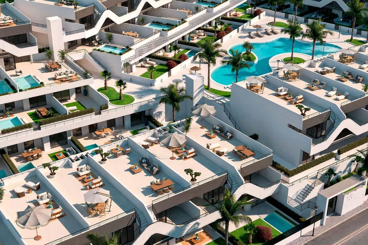 Dichtbij luchtfoto van het appartementcomplex met detail van zwembaden en groene ruimtes in Alfas del Pi.