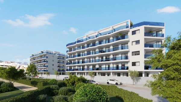 Buitenzicht op een modern 1-slaapkamer appartementengebouw in Mijas, Costa del Sol, omgeven door groen.