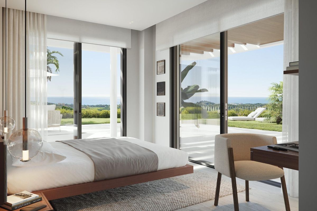Stijlvolle slaapkamer met grote ramen, uitzicht op de tuin en landschap in penthouse in Mijas.