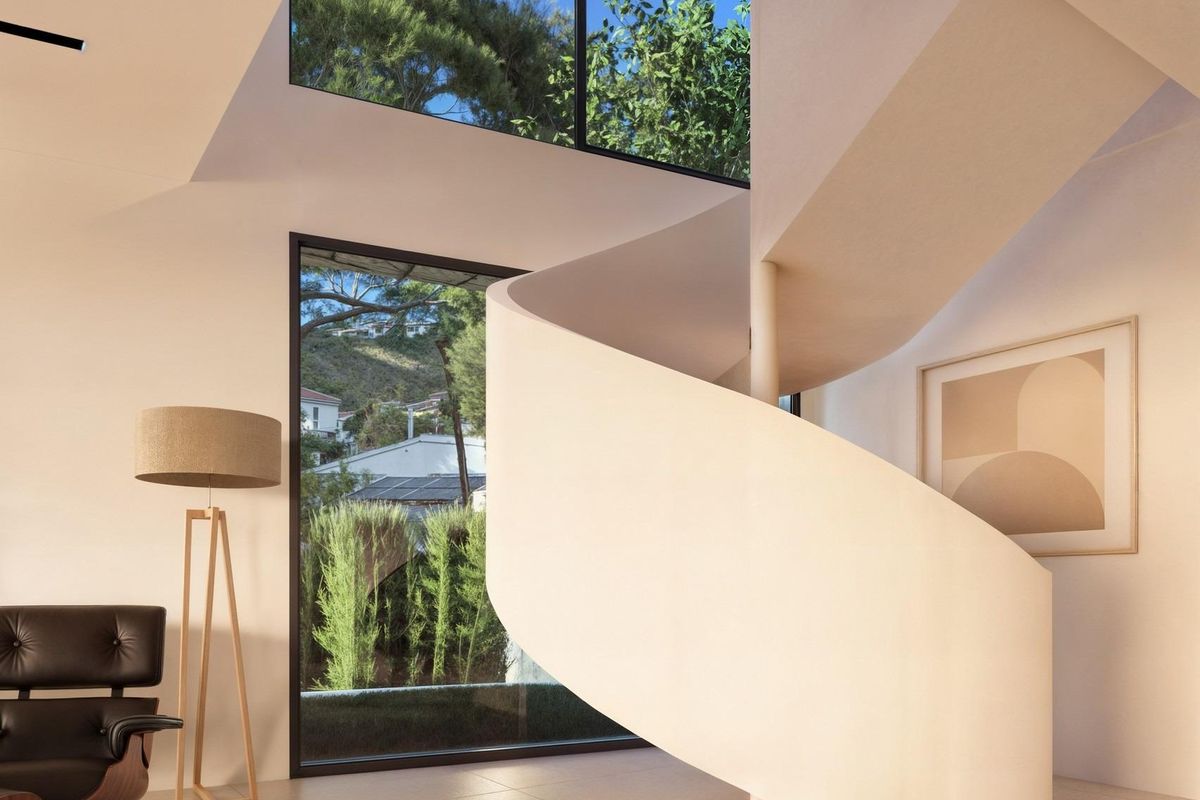 Elegante spiraaltrap in de villa, omringd door licht en modern decor in Moraira.