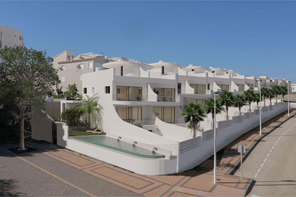 Stijlvol appartementencomplex in Torrevieja met zwembad en palmbeplanting bij de kustweg.