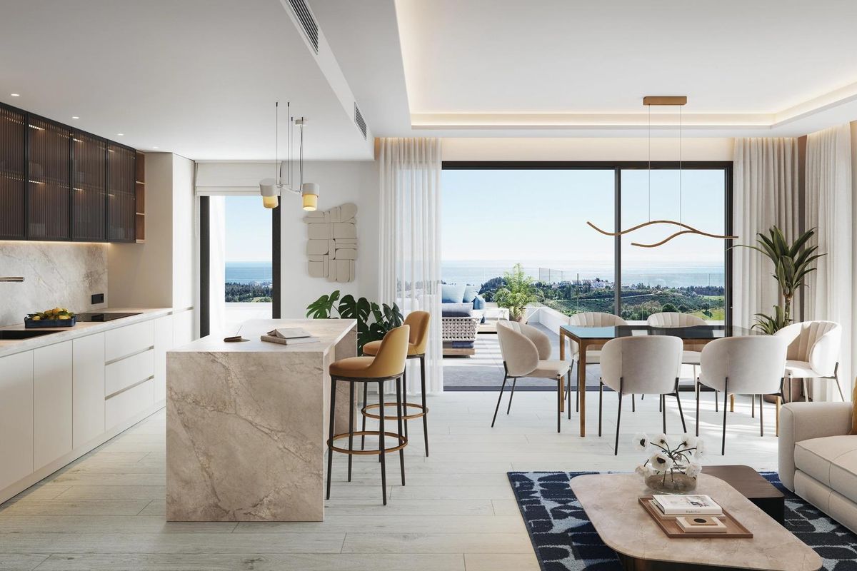 Heldere en moderne keuken in een appartement in Mijas, met een eiland en uitzicht op zee vanuit de ramen.