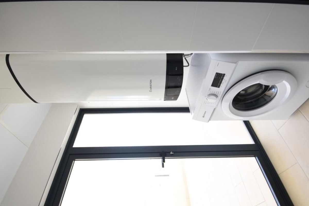 Waskamer met wasmachine en opslag in een lichte ruimte van het appartement, gelegen in San Miguel de Salinas.