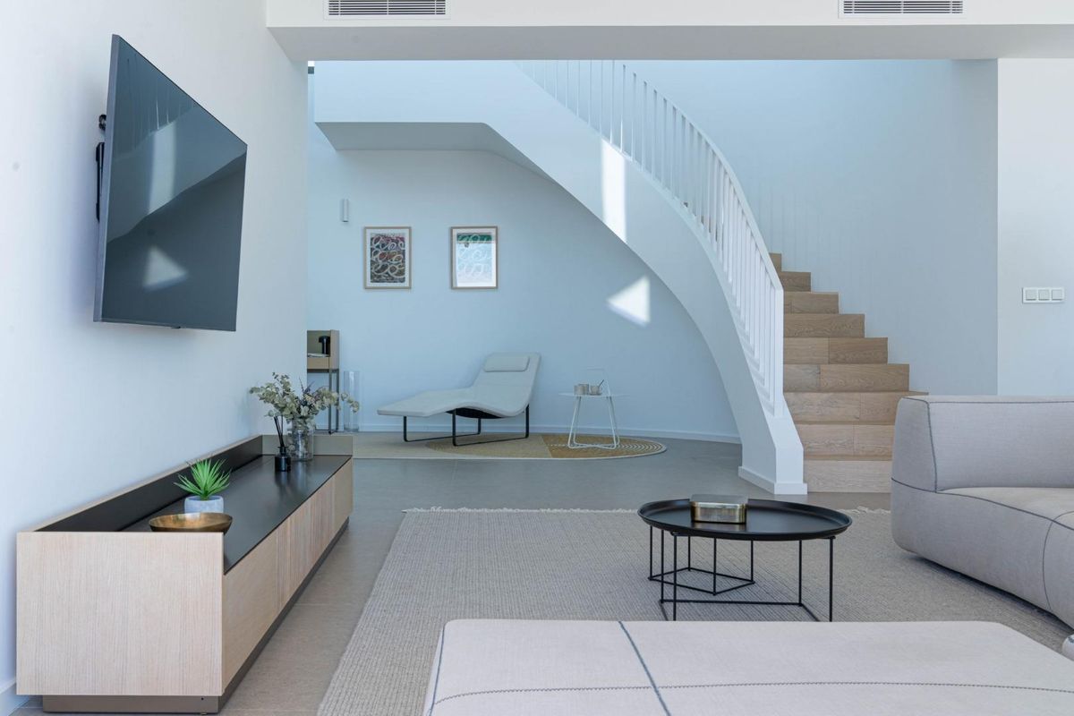 Open living area in the villa featuring a stylish staircase and natural light flooding into the space.