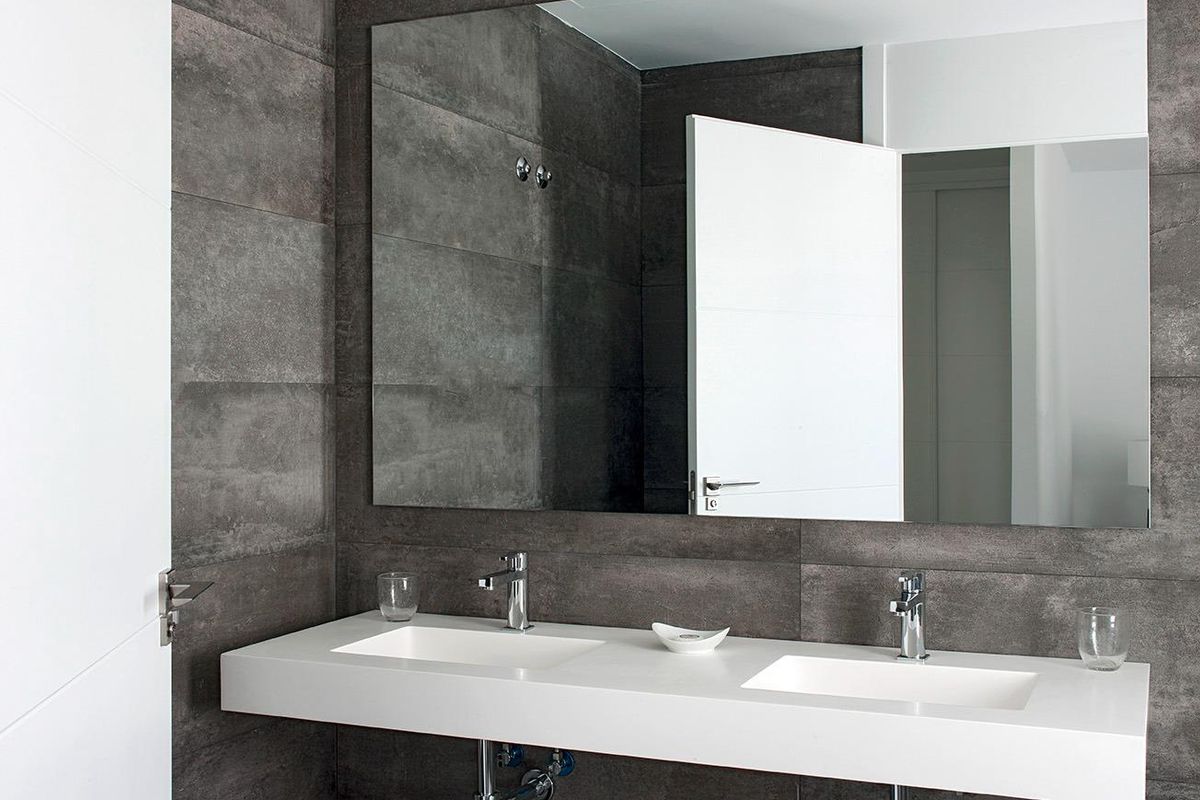 Elegante badkamer in een villa met 3 slaapkamers, met stijlvolle armaturen en een grote spiegel, gelegen in La Manga Club, Costa Calida.