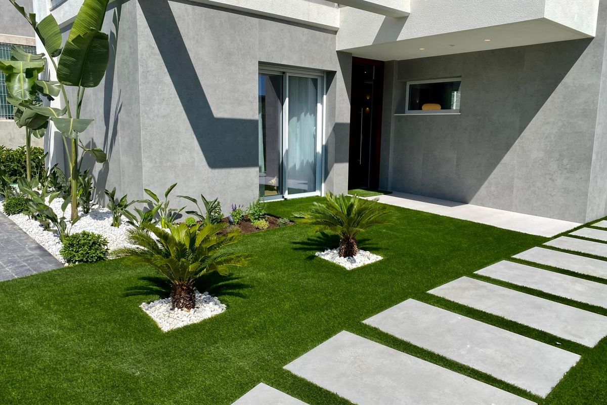 Close-up van de ingang van de villa in Finestrat, die de tuin en het padontwerp toont.