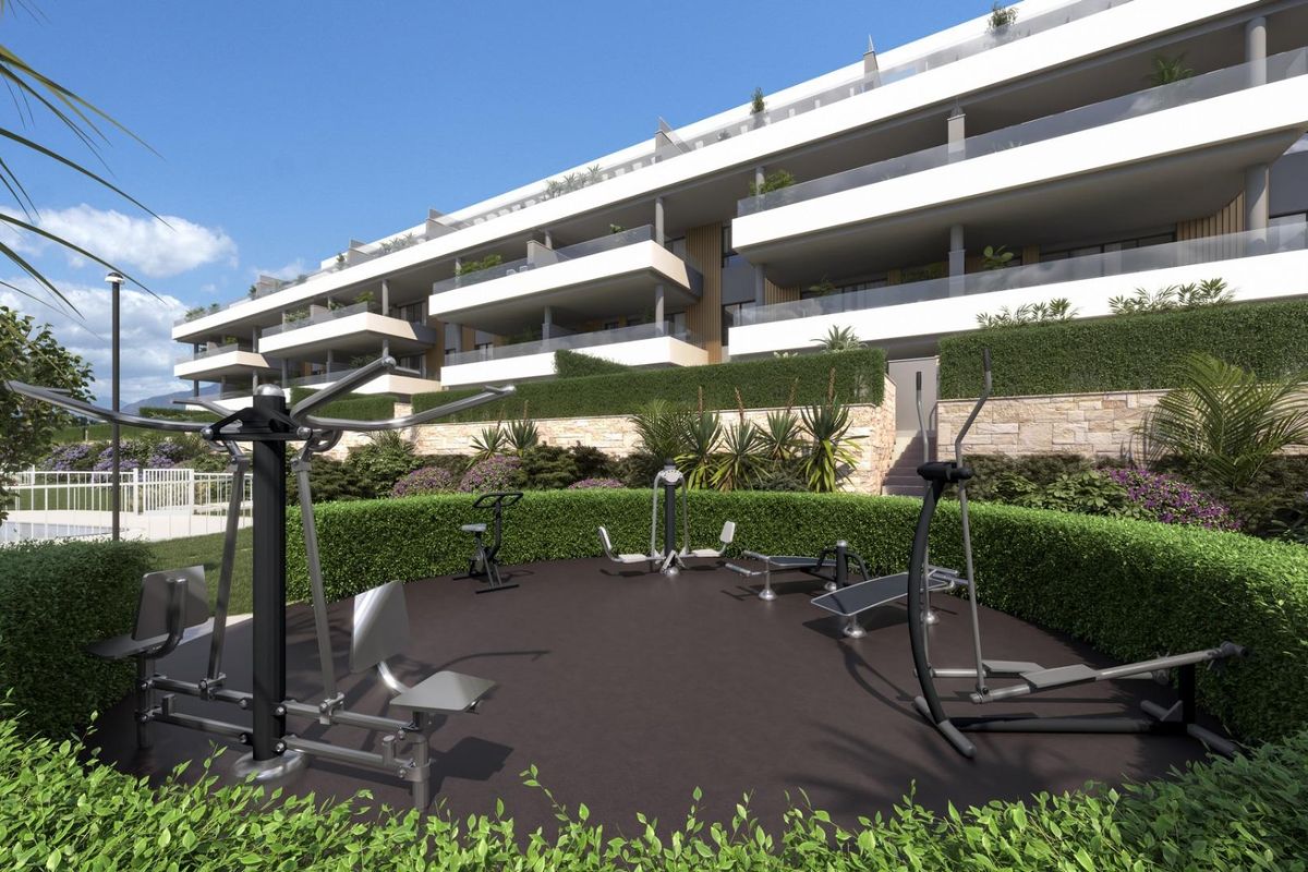Buitensportfaciliteiten bij het appartementcomplex in Torremolinos, met fitnessapparatuur en groen.