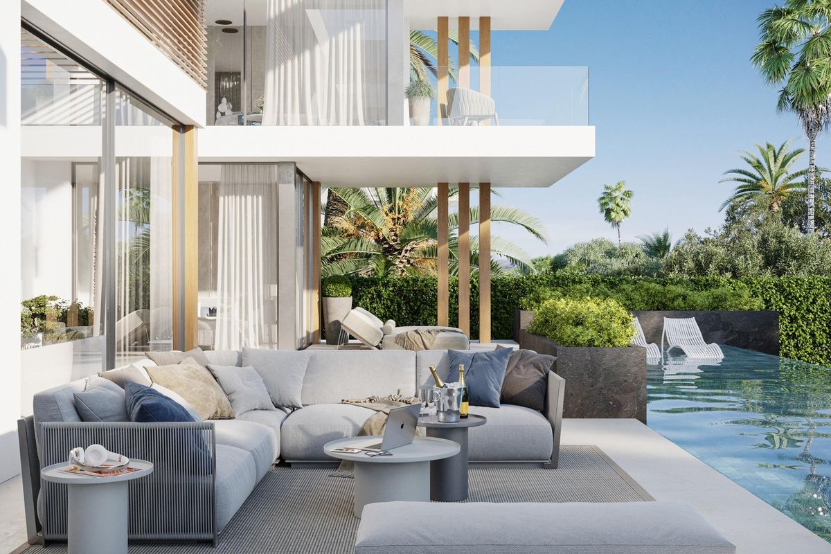 Luxueus terras met zithoek naast het zwembad van een villa in Marbella, omringd door weelderig groen.