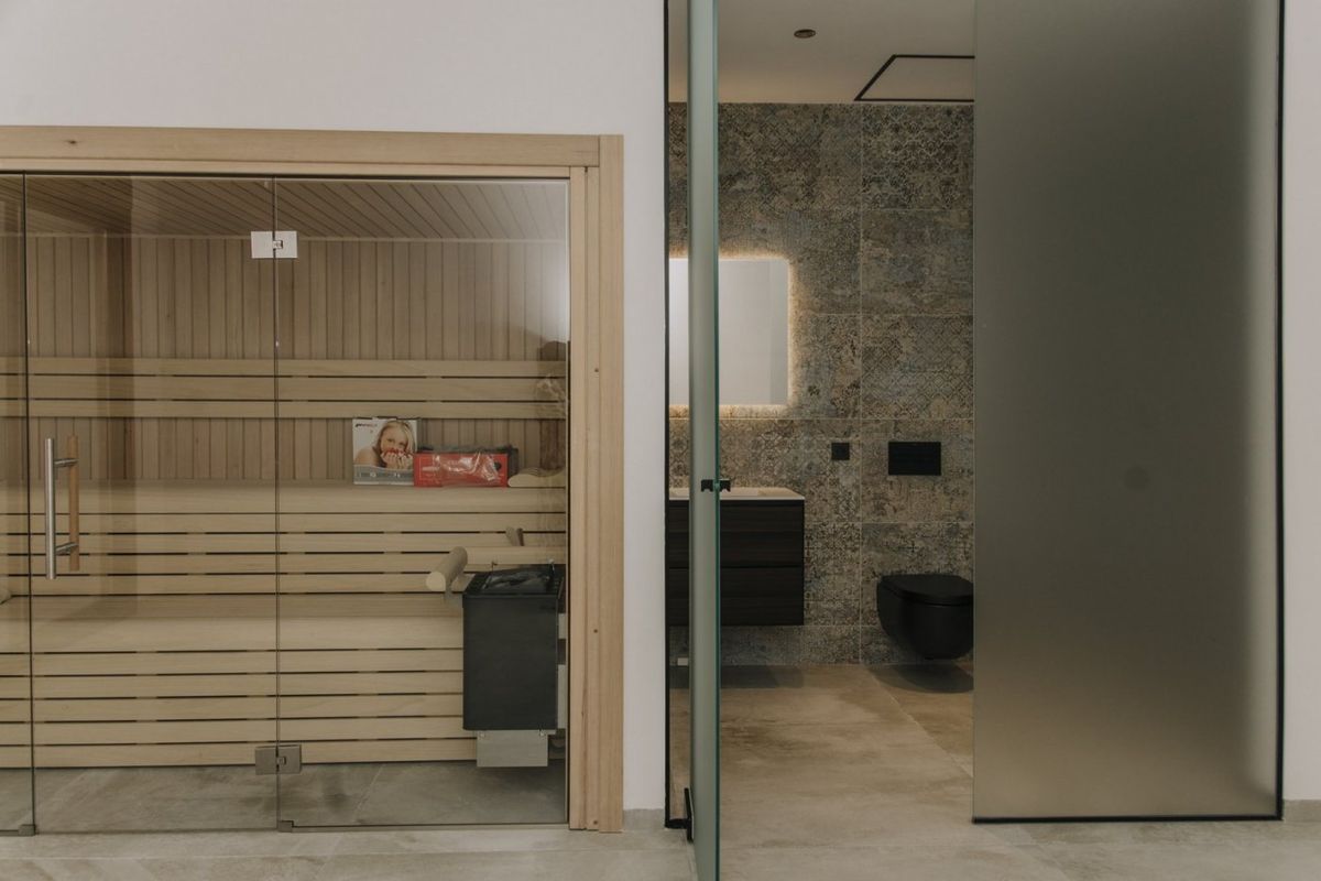 Ontspannend sauna-gebied dat leidt naar een moderne badkamer in een villa in Rojales, met nadruk op wellness en luxe.