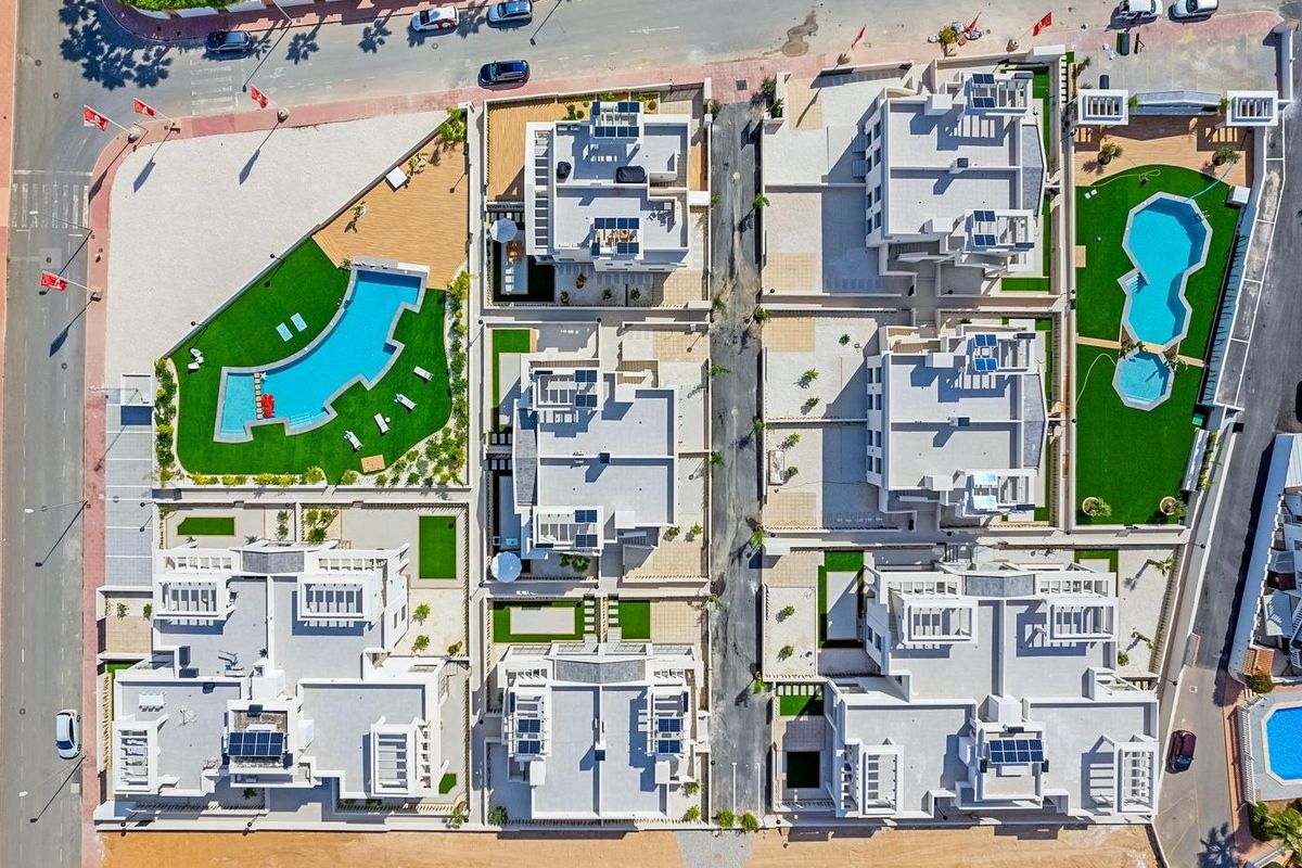 Bovenaanzicht van een luxe wooncomplex met meerdere gebouwen en aangelegde zwembaden in Rojales.