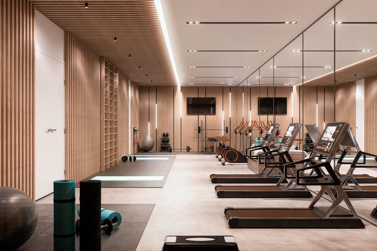 Moderne gym in een penthouse in Marbella met spiegelwanden en houten accenten, voorzien van fitnessapparatuur.